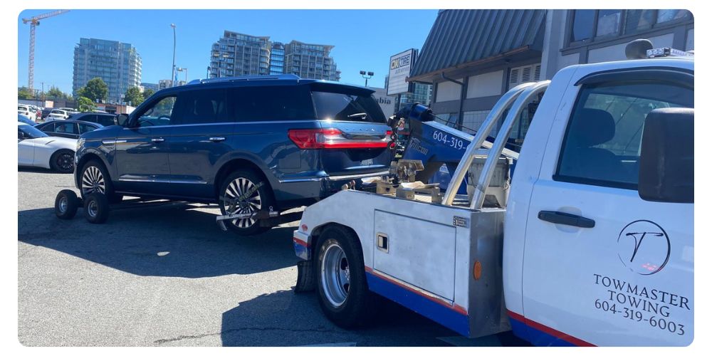 TowMaster Towing truck towing a luxury SUV in an urban parking lot