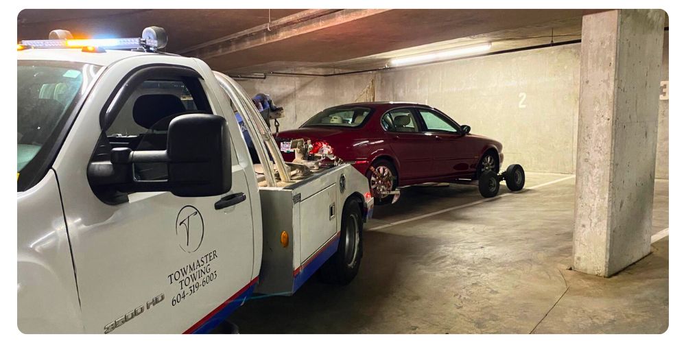 TowMaster Towing truck towing a car from an underground parking garage